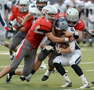 Mt. Spokane running back Roy Hyatt (5) is wrapped up by Ferris' Kole Karstetter, left, and Brad Dickinson, right, in the first half Friday, Oct. 11, 2013 at Joe Albi Stadium. Ferris outlasted the Wildcats 24-14. (Jesse Tinsley / The Spokesman-Review)