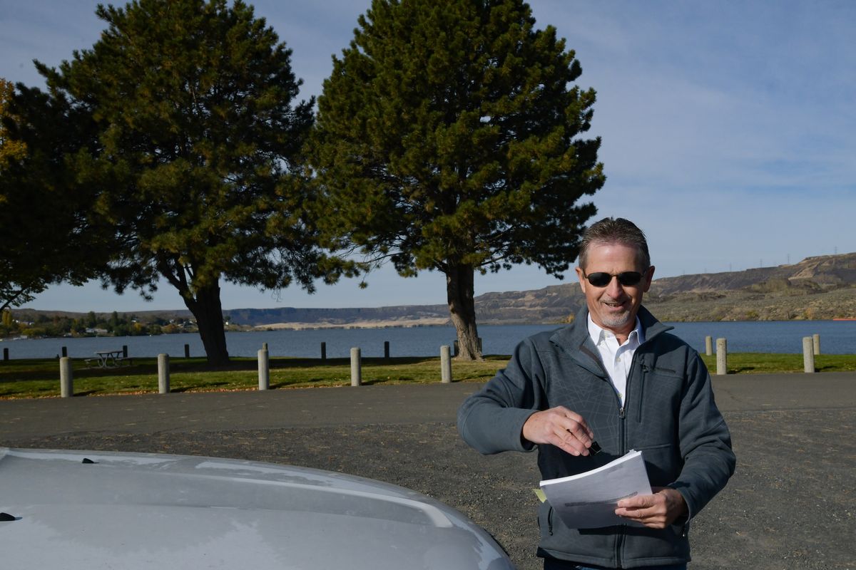Darvin Fales smiles as he shows plans at the site where Columbia Basin Hydropower hopes to build a massive, $1.4 billion pumped storage hydropower project on Banks Lake, which feeds into Lake Roosevelt on Tuesday,Oct 12, 2021, outside Electric City, Wash.  (Tyler Tjomsland/The Spokesman-Review)