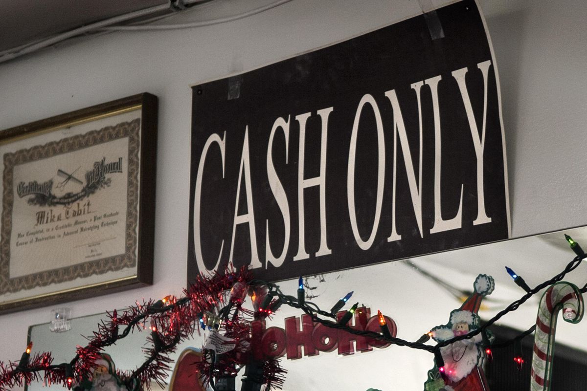 The cash only sign is prominently displayed at Dan's Barber Shop in Spokane on Wednesday, Dec. 27, 2017.The shop has been in operation for 60 years. (Kathy Plonka / The Spokesman-Review)