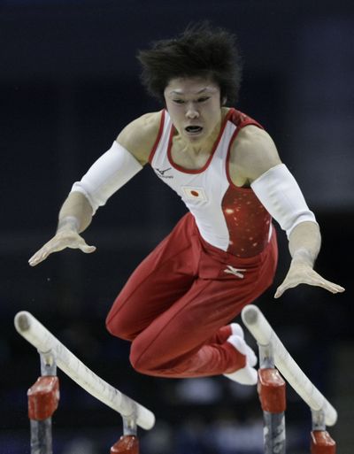 Kohei Uchimura of Japan performs on the parallel bars during the World Gymnastics Championships. He won the overall title.  (Associated Press / The Spokesman-Review)