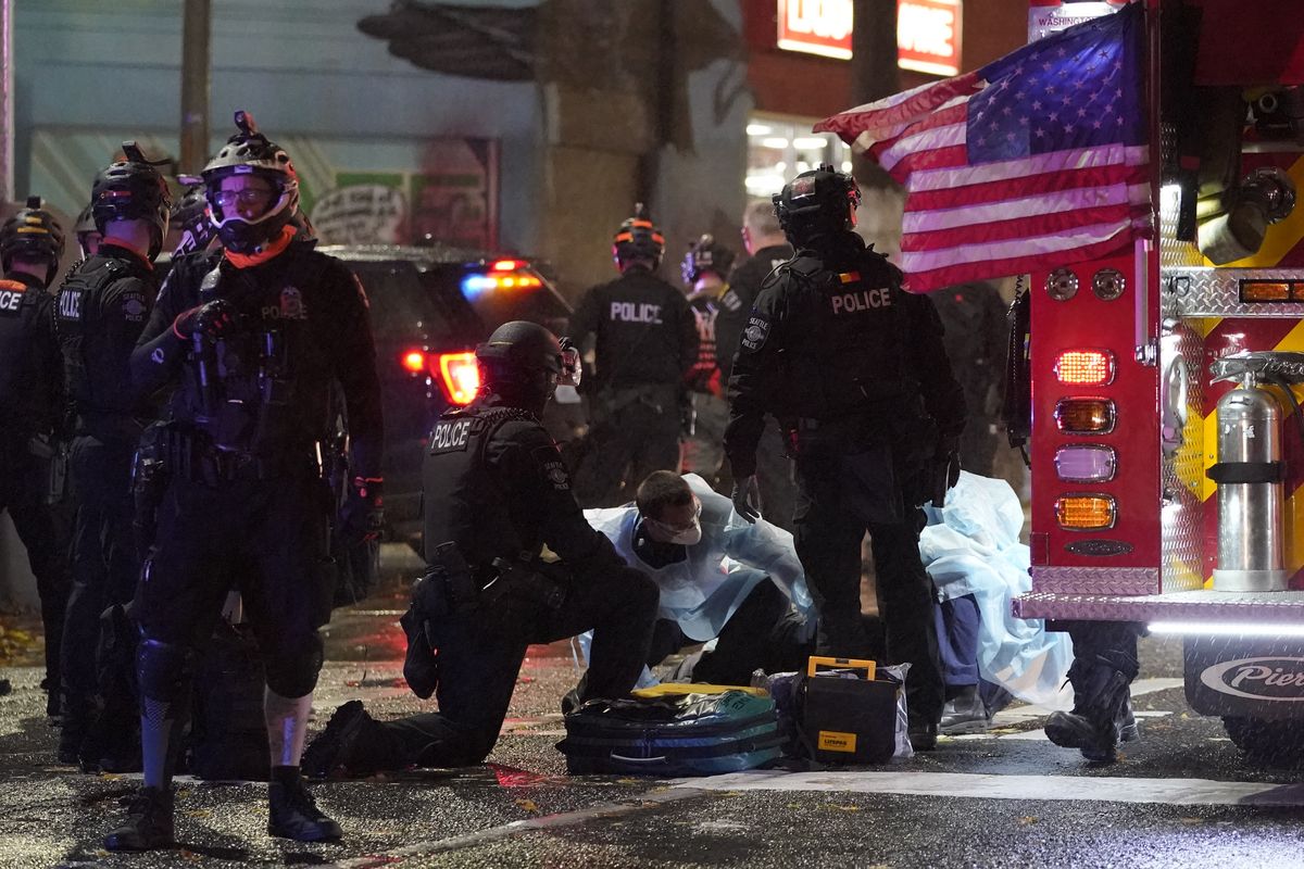 Emergency crews attend an injured man detained by police during a protest after the Nov. 3 elections in front of the east precinct station, Wednesday, Nov. 4, 2020, in Seattle.  (Associated Press)