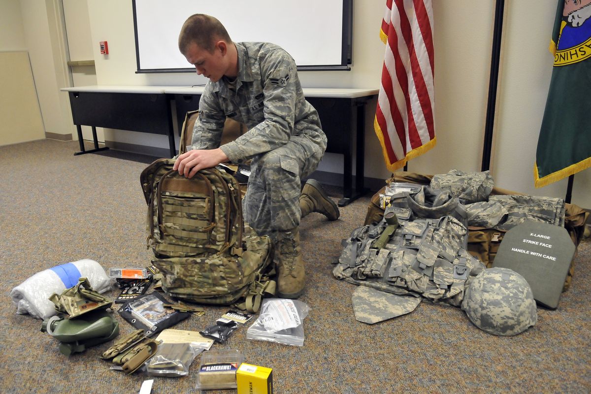 Airman 1st Class Christopher Munro unpacks a bag of new gear in a classroom where the 141st Civil Engineering Squadron was preparing for an upcoming deployment Saturday at Fairchild Air Force Base. The unit will head to Afghanistan after a month of combat training in Texas. (PHOTOS BY JESSE TINSLEY)
