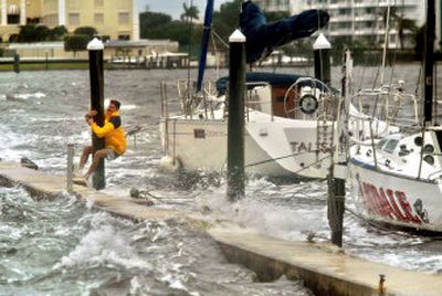 
Todd Goldsberry clings to a piling while making his way back to shore from his sailboat 
