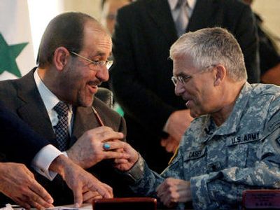 
Prime Minister Nouri al-Maliki  takes a pen from Gen. George Casey, the top U.S. commander in Iraq, after signing a paper  that  puts al-Maliki in control of Iraq's military. 
 (Associated Press / The Spokesman-Review)