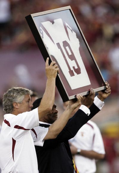 USC coach Pete Carroll, left, and athletic director Mike Garrett hold the football jersey of kicker Mario Danelo during a memorial ceremony before the Trojans' season opener against Idaho on Sept. 1. Associated Press
 (Associated Press / The Spokesman-Review)