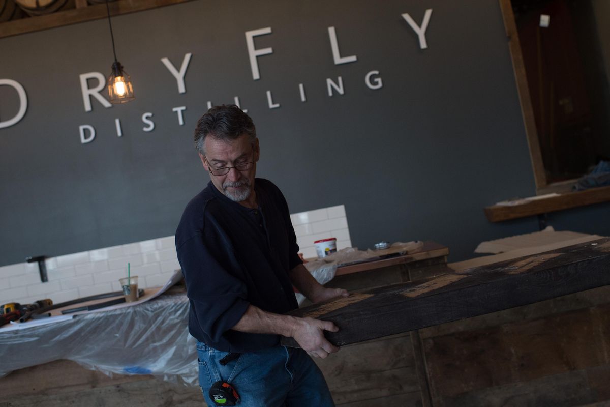Brad Barrick carries a piece of reclaimed lumber at the Dry Fly Distilling Tasting Room in this file photo from Thursday, March 9, 2017. (Tyler Tjomsland / The Spokesman-Review)
