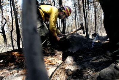 A group of firefighters from the Methow Valley work on hot spots west of Ely Lane, in the Spokane Valley.  (Brian Plonka / The Spokesman-Review)