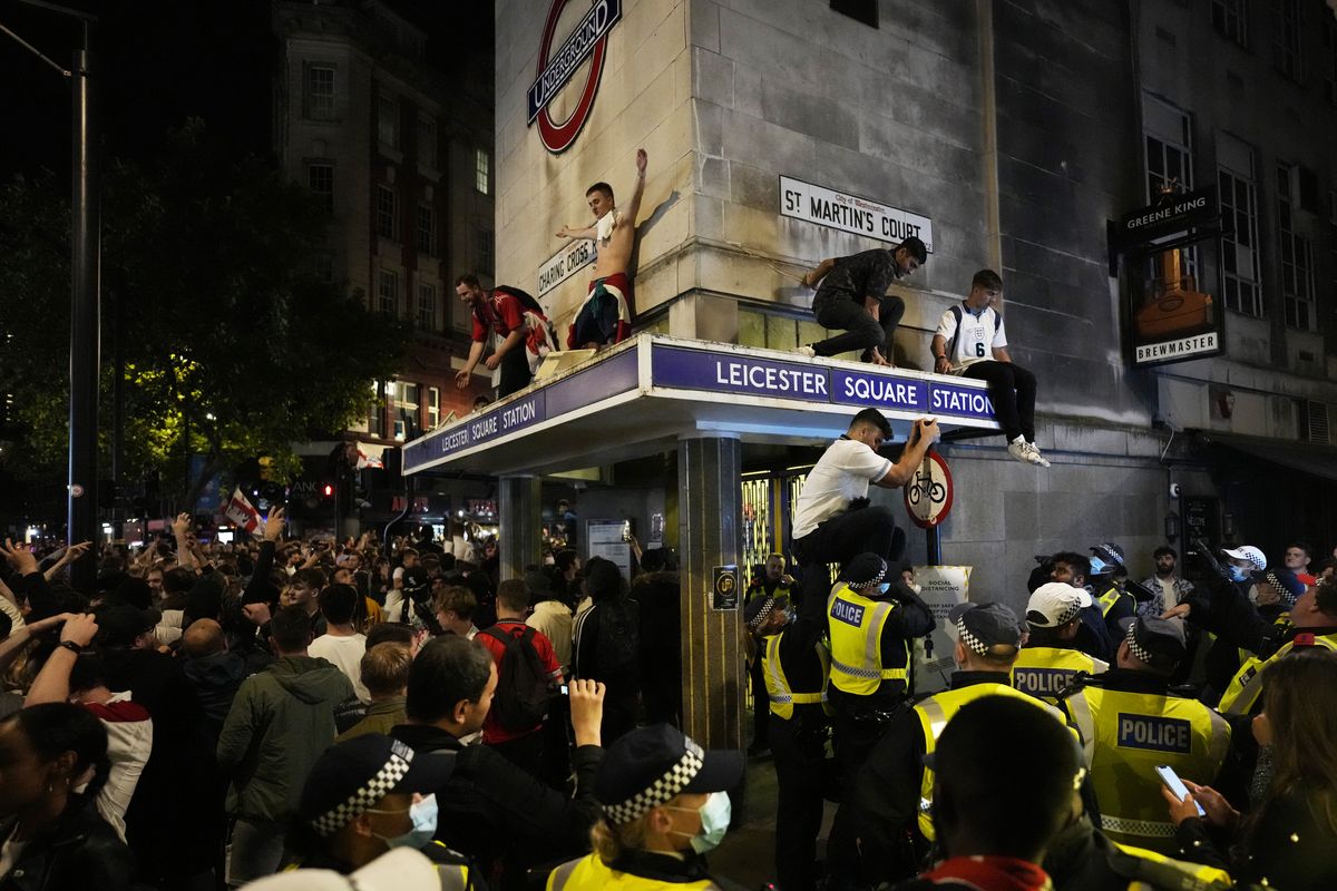 England fans react as they stand on the roof of Leicester Square underground station after England won the Euro 2020 soccer championship semifinal match between England and Denmark played at Wembley Stadium in London, Wednesday, July 7, 2021.  (Matt Dunham)