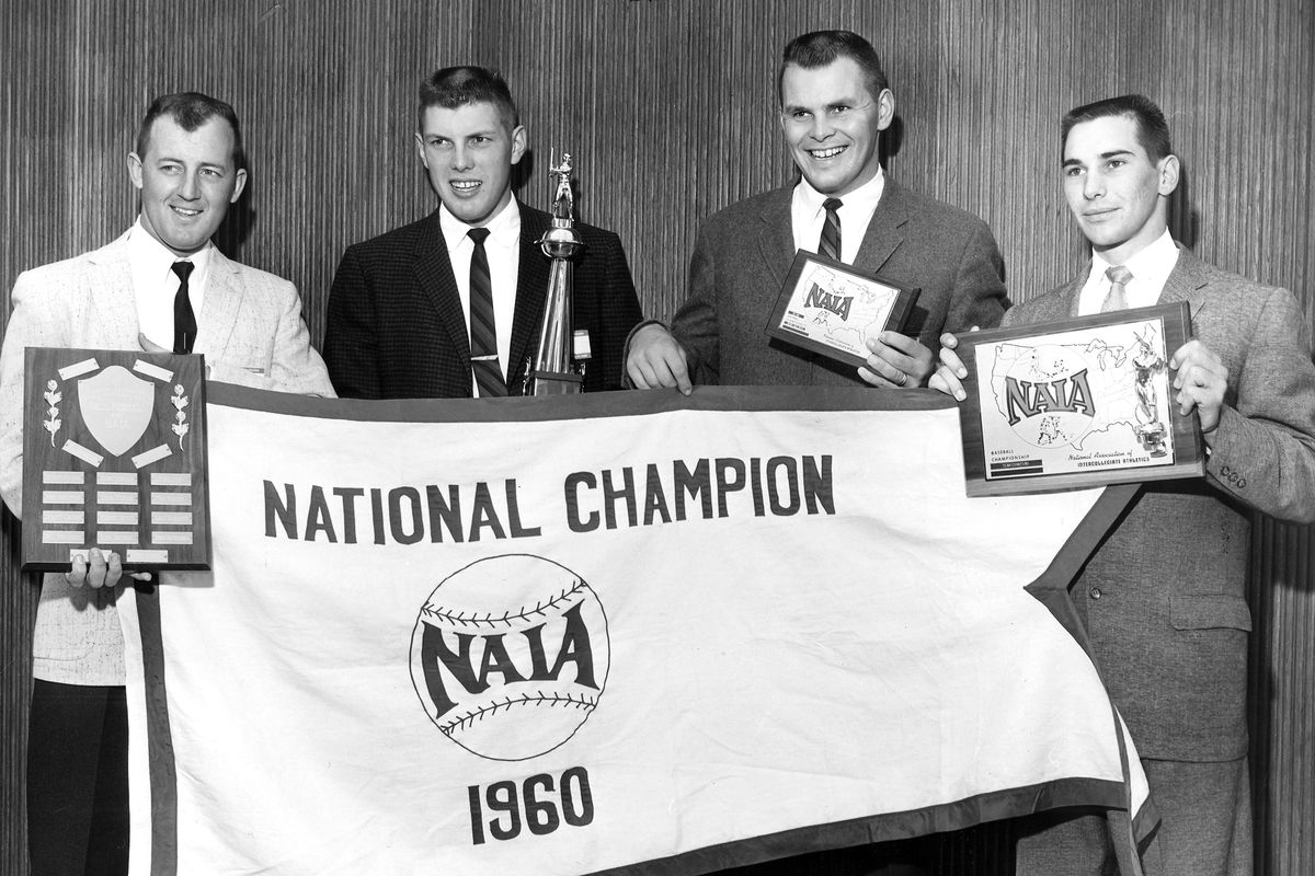 Four members of the 1960 Whitworth College team pose with their national championship awards. They are, from left: Dale Roberts, holding the award given to coach Paul Merkel; Ray Washburn, most valuable player; Ron Lince, with Washburn’s trophy for the all-tournament team; and Norm Harding, with the championship trophy.