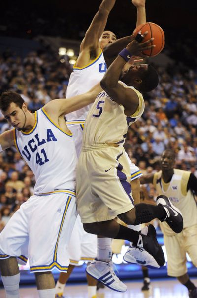 Washington’s Justin Dentmon (5) goes to the basket as UCLA’s Nikola Dragovic (41) and Drew Gordon defend.   (Associated Press / The Spokesman-Review)