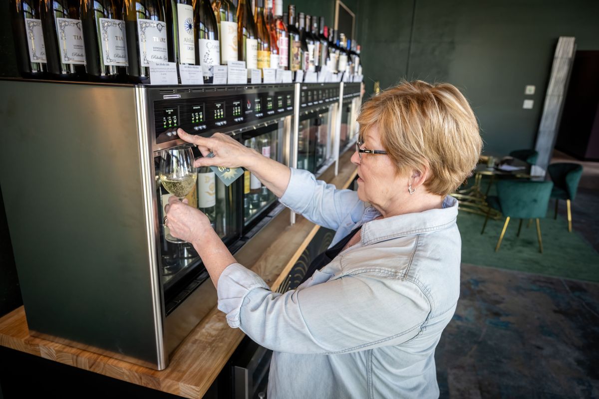 Barbara Grubb pours herself a glass of white wine from the self-serve wine bar at 1919 Wine Cellar, at 1919 E. Sprague Ave., on June 15. (COLIN MULVANY/THE SPOKESMAN-REVIEW)