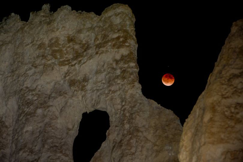  The moon is eclipsed by the Earth's shadow early Tuesday, April 15, 2014 as seen from Bryce Canyon, Utah. For some, the moon appeared red-orange because of the sunsets and sunrises shimmering from Earth, earning it the name 