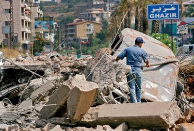 
A Lebanese worker inspects damage to a telephone line wrapped  around a car on the Maameltein bridge in Jounieh, north of Beirut, Lebanon, on Friday  after an Israeli airstrike. 
 (Associated Press / The Spokesman-Review)