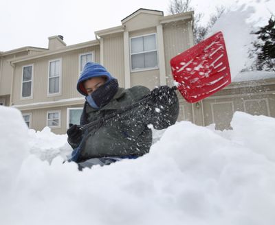 Lewis Smith, age 13, shovels snow as he builds an igloo in front of his home in Overland Park, Kan. Friday, Dec. 25, 2009. A fierce Christmas storm dumped more snow and ice across the nation's midsection Friday after stranding travelers as highways and airports closed and leaving many to celebrate the holiday just where they were. (Charlie Riedel / Associated Press)