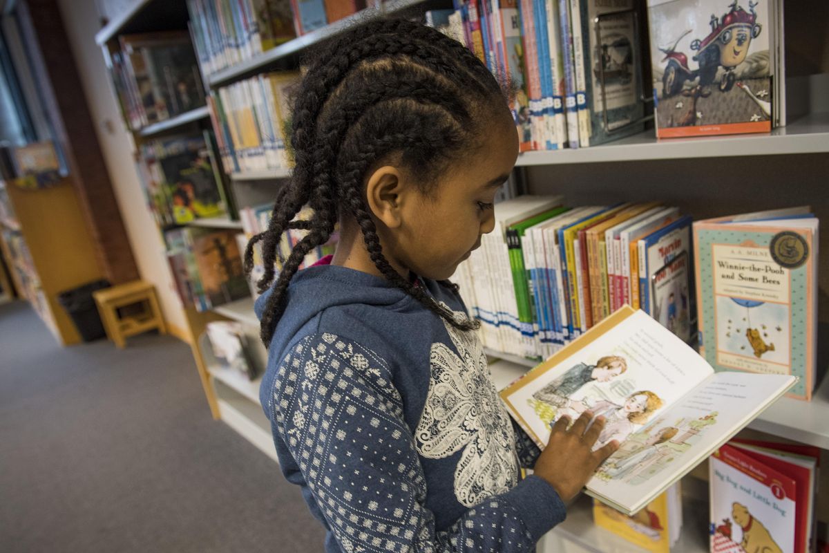 Heamen Afework, 7 looks for a book to check out of the South Hill branch of the Spokane Public Library, Friday, Dec. 22. 2017. City leaders are already discussing a plan for the future site of an expanded South Hill library at Thornton Murphy Park. The new facility will be built if voters approve a construction bond for Spokane libraries, expected to go to the ballot in 2018. Construction wouldn