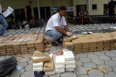
A Colombian policeman inspects sacks of 15 tons of cocaine seized Thursday in Tumaco, Colombia. 
 (Associated Press / The Spokesman-Review)