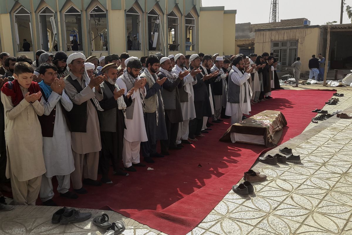 Relatives and residents pray during a funeral ceremony for victims of a suicide attack at the Gozar-e-Sayed Abad Mosque in Kunduz, northern Afghanistan, Saturday, Oct. 9, 2021. The mosque was packed with Shiite Muslim worshippers when an Islamic State suicide bomber attacked during Friday prayers, killing dozens in the latest security challenge to the Taliban as they transition from insurgency to governance.  (Abdullah Sahil)