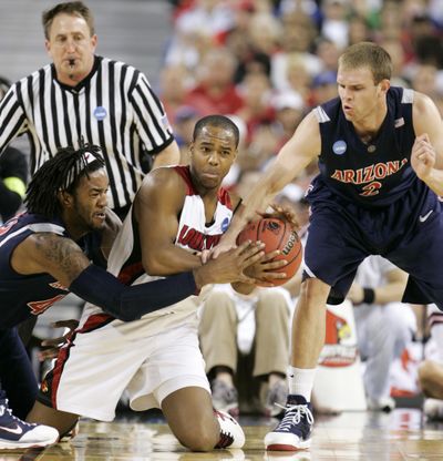 Arizona’s Jordan Hill, left, and Zane Johnson, right, try to pry the ball from Louisville’s Preston Knowles in the second half.  (Associated Press / The Spokesman-Review)