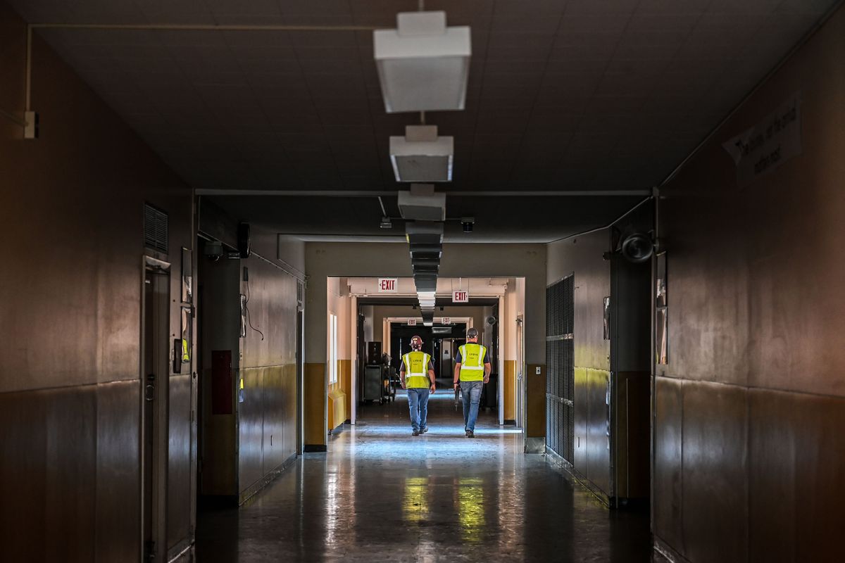 Lydig Construction workers walk the main hallway of the old Sacajawea Middle School, Monday, June 26, 2023, in Spokane.  (DAN PELLE/THE SPOKESMAN-REVIEW)