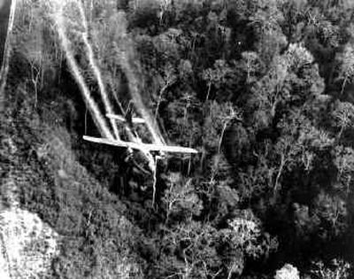 
A U.S. Air Force C-123 sprays defoliants on a Vietnamese jungle in 1966. 
 (File/Associated Press / The Spokesman-Review)
