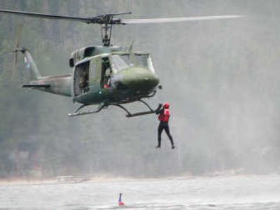 
36th Rescue Flight helicopter hoists one of two medics out of the water in a simulated rescue training exercise with Priest Lake Search and Rescue.
 (Pecky Cox / The Spokesman-Review)