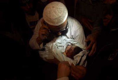 
Nasser Al-Borai holds the body of his six-month old son, who  was killed in an Israeli airstrike on Gaza City late Wednesday.
 (The Spokesman-Review)