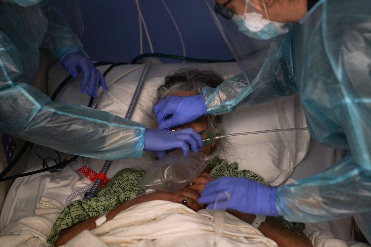 FILE - In this Jan. 7, 2021, file photo, two nurses put a ventilator on a patient in a COVID-19 unit in Orange, Calif. With more than 600,000 Americans dead of COVID-19 and questions still raging about the origin of the virus and the government