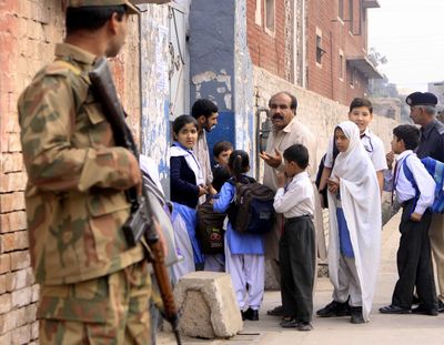 A Pakistan army soldier stands guard outside a local school in Peshawar on Monday.  (Associated Press / The Spokesman-Review)