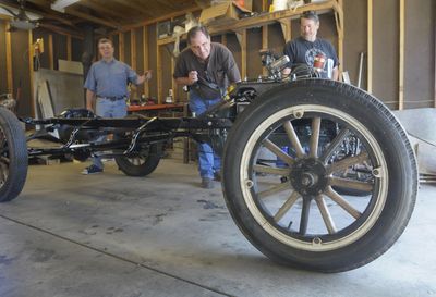 Alan Stacey, center, tries the mechanics of the 1926 Ford Roadster being restored by a group of Hillyard friends. Kerry Tritt, left, and Craig Nelson look on.  (Christopher Anderson / The Spokesman-Review)