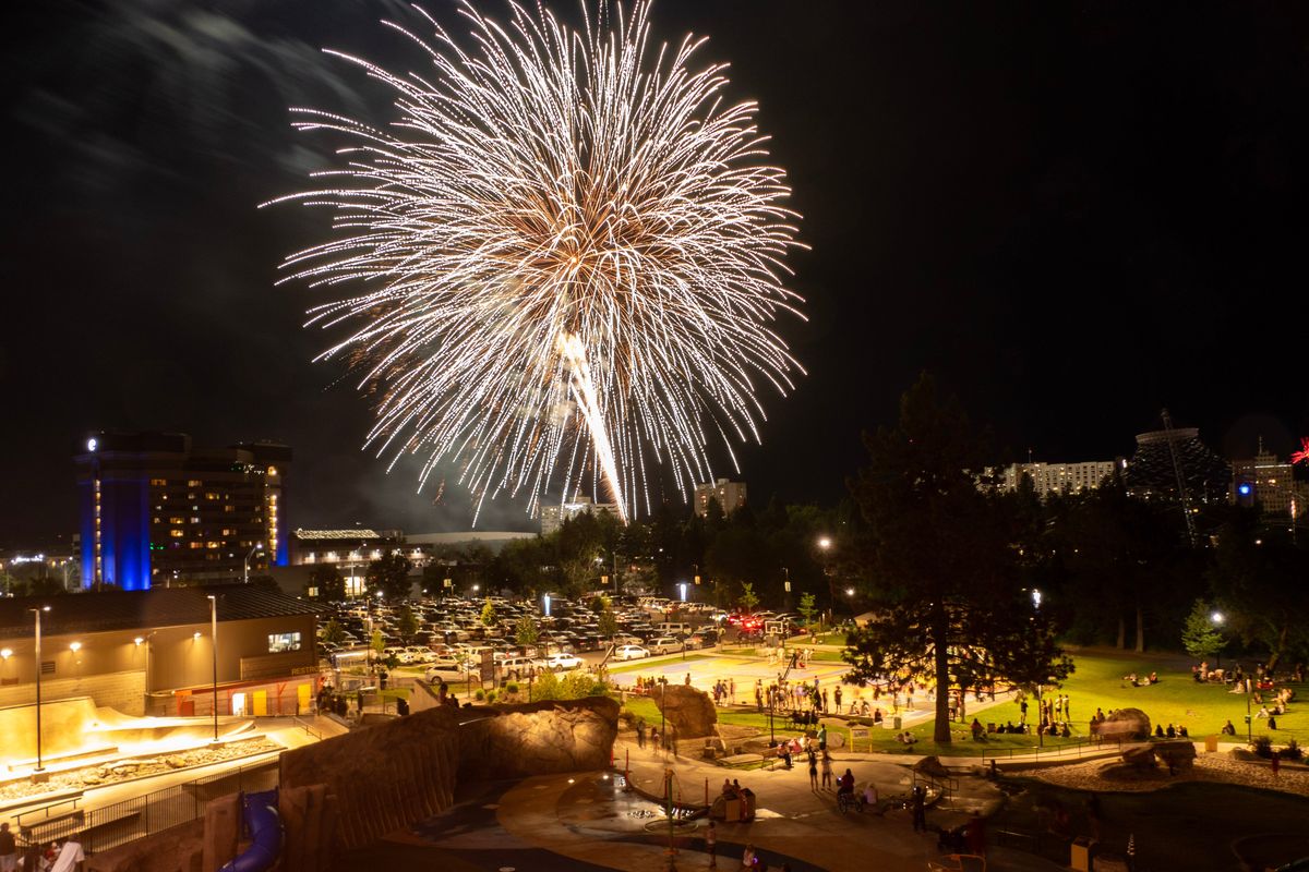 Young and old alike pause their play on the northeast section of Riverfront Park to watch Fourth of July fireworks burst overhead in Spokane in 2024.  (JESSE TINSLEY/The Spokesman-Review)