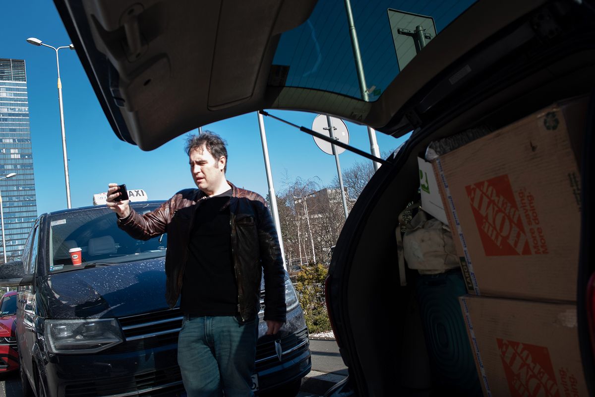 Kyle Varner films himself for several Spokane television stations while loading medical supplies into a van in Warsaw, Poland on March 10, 2022. Supplies included chest tubes, surgical instruments, gowns, IV supplies, tourniquets, bandages, portable ultrasound devices and more.  (Eli Francovich/The Spokesman-Review)