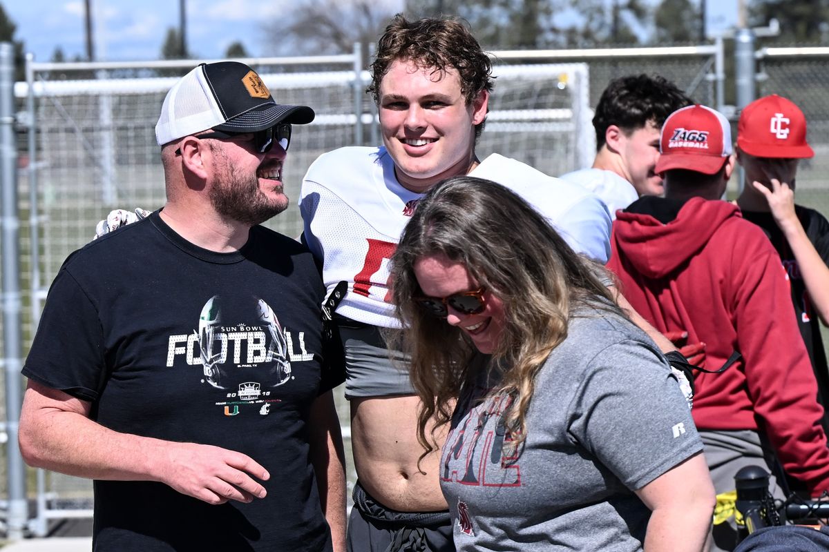 Washington State defensive end Matyus McLain hugs his mother, Juliann, as his father, Drew, smiles at him following a practice on Saturday in Mead.  (Tyler Tjomsland/The Spokesman-Review)