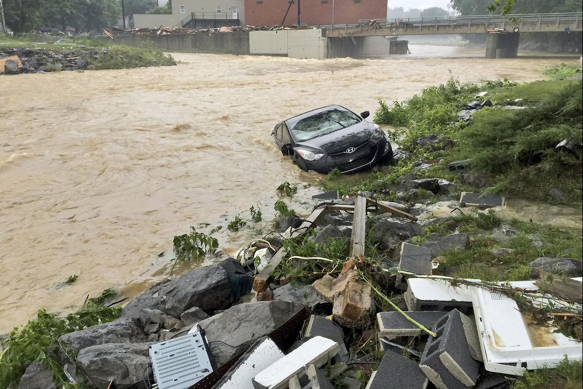 In this photo released by the The Weather Channel, a vehicle rests on the in a stream after a heavy rain near White Sulphur Springs, W.Va., Friday, June 24, 2016. Multiple fatalities have been reported in flooding that has devastated parts of the state, a state official said Friday morning. (Justin Michaels / The Weather Channel via Associated Press)