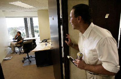 
Blanchard and Co. CEO Don Doyle, right, looks in on senior account executive Ed Wehrman in their company's sparsely equipped offices in Addison, Texas, on Tuesday. 
 (Associated Press / The Spokesman-Review)