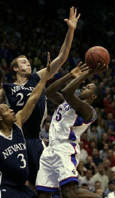 
Nevada's Kyle Shiloh, left, and Nick Fazekas try to block a shot by Kansas guard Mario Chalmers. 
 (Associated Press / The Spokesman-Review)