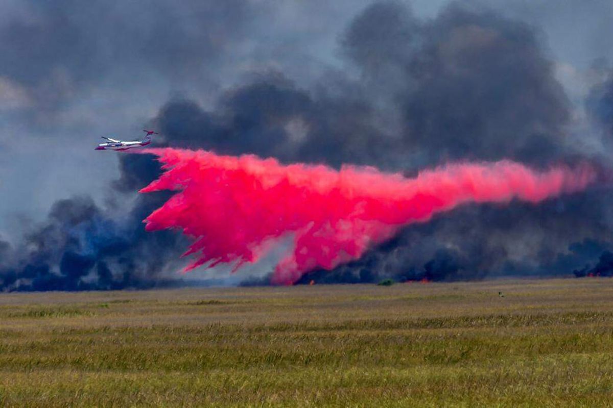 A plane drops fire retardant on a large wildfire on the south side of Tamiami Trail on Tuesday. (Miami Herald )