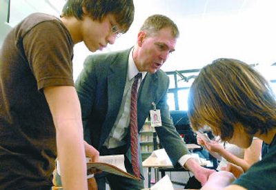 
Post Falls School Superintendent Jerry Keane helps Hayden Booth, right, and Kirk Payne fill out their workbooks during his class about budgeting and personal finance in an honors English class at River City Middle School on Wednesday. Keane teaches the class once a week. 
 (Photos by JESSE TINSLEY / The Spokesman-Review)