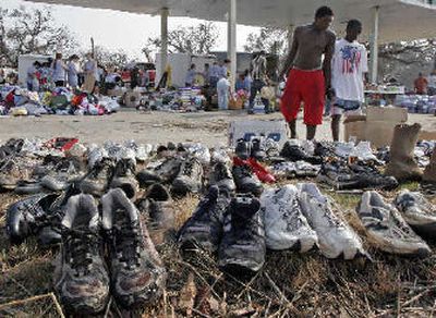 
Youths search for a pair shoes in a donation area set up in a destroyed gas station in West Biloxi, Miss., on Monday. Hurricane Katrina has left thousands in need of clothes.
 (Associated Press / The Spokesman-Review)