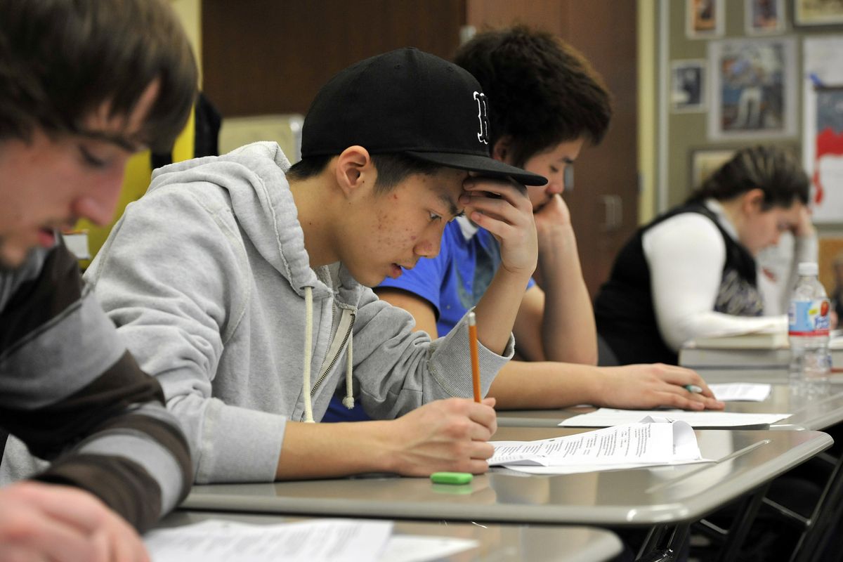 Rogers High School seniors, from left, Robert Robertson, Cody Moua, Tan Pham and Kim Jeske take a test in their Advanced Placement European History class on Tuesday. The graduation rate in the school went up 19 percentage points in 2011 over the previous year. (Dan Pelle)