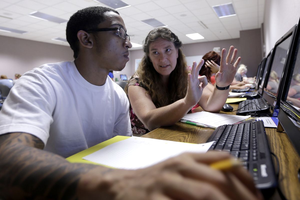 Math teacher Thora Broyles, right, counts on her fingers in an effort to help student Jamal Mabry in a remedial math class Tuesday, Aug. 28, 2012, at Missouri State University-West Plains in West Plains, Mo. At the two-year school in south-central Missouri, fully 75 percent of first-year students take at least one remedial class, well above the national average of 50 percent at community colleges and 20 percent at four-year schools. (Jeff Roberson / Associated Press)