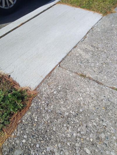 The concrete at the top left is brand new. The concrete sidewalk next to it could be 60 or more years old. Note it’s not cracked; only the top layer has worn off. (Tim Carter)