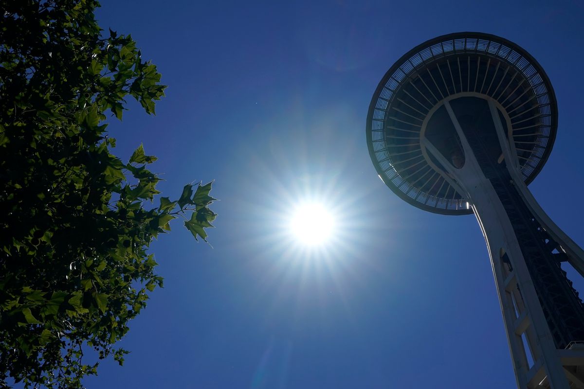 The sun shines near the Space Needle on June 28 in Seattle as it and other cities broke all-time heat records, with temperatures soaring well above 100 degrees.  (Ted S. Warren)