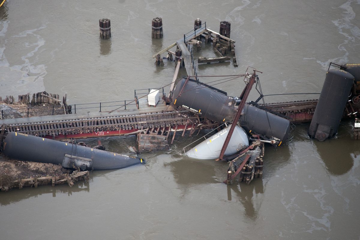 Several cars lay in the water after a freight train derailed in Paulsboro, N.J., Friday, Nov. 30, 2012. People in three southern New Jersey towns were told Friday to stay inside after the freight train derailed and several tanker cars carrying hazardous materials toppled from a bridge and into a creek. (Cliff Owen / Fr170079 Ap)