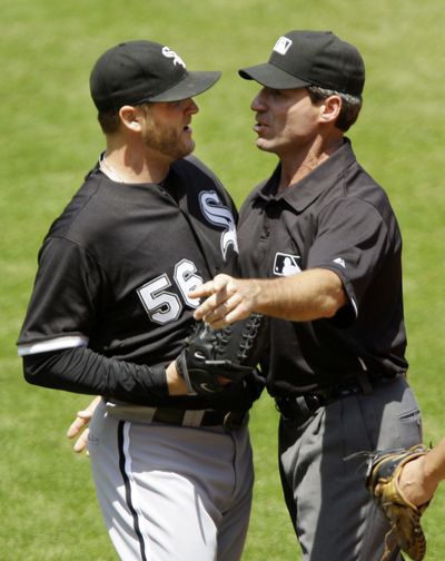 Umpire Angel Hernandez pushes White Sox pitcher Mark Buehrle to the dugout after Buehrle’s ejection Wednesday. (Associated Press)