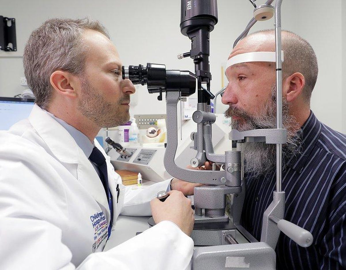 Dr. Aaron Nagiel, of The Vision Center at Children’s Hospital Los Angeles, examines Seattle resident Toby Willis’ right eye on the morning after Willis received his second gene-therapy treatment. Willis was the first adult to get the treatment since its approval, and hopes it will keep his progressive vision loss from getting worse, and perhaps lead to slight improvements. (Children’s Hospital LA / Courtesy)