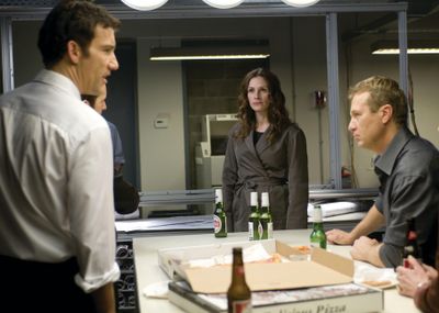 ORG XMIT: NYET251 In this film publicity image released by Universal Pictures, Clive Owen, left, Julia Roberts, and Oleg Stefan are shown in a scene from, 