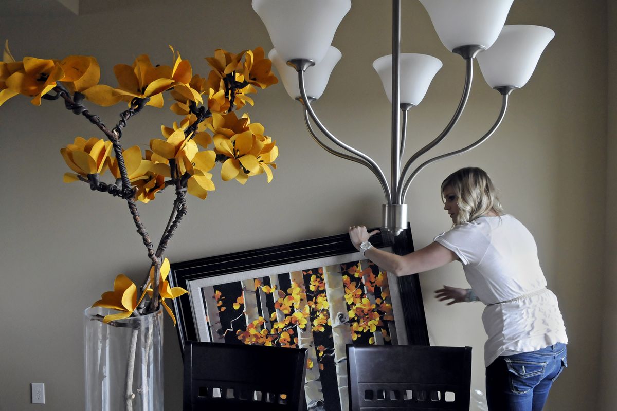 Tin Roof employee Meghan Page unwraps American-made furniture on Wednesday inside a home in Eagle Ridge. (Dan Pelle)