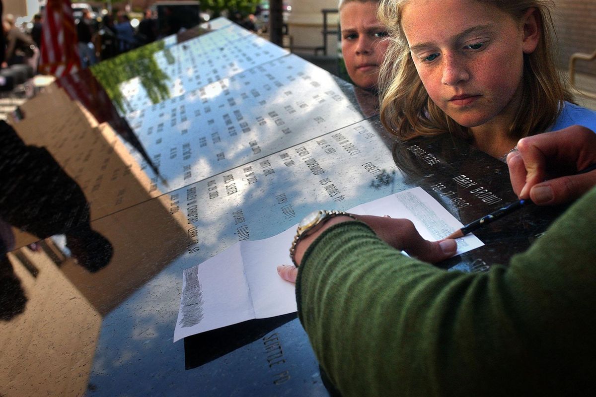 Abby Liss, 10, and her brother TJ, 9, watch as their mother Jennifer Saunders-Liss makes a copy of her brother