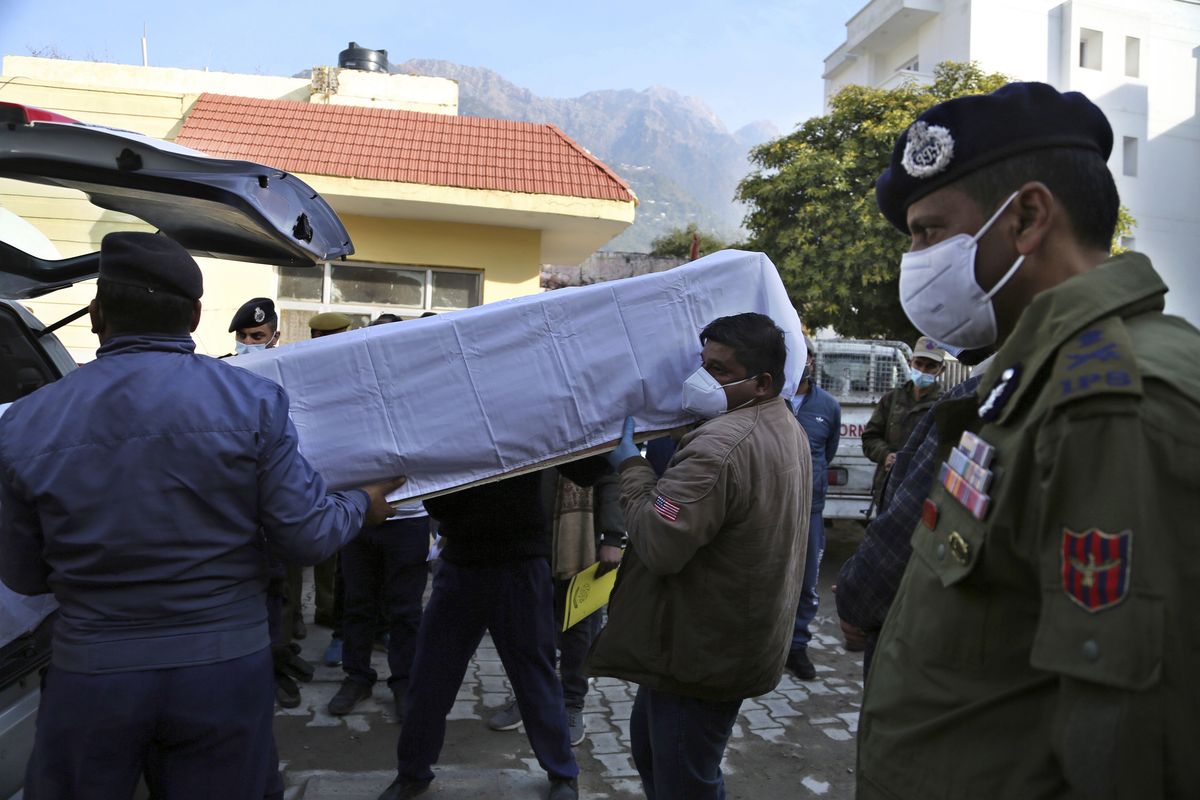 Health workers carry the coffin of a victim, who died in a stampede at the Mata Vaishnav Devi shrine, at a hospital in Katra, India, Saturday, Jan. 1, 2022. A stampede at a popular Hindu shrine in Indian-controlled Kashmir killed at least 12 people and injured 13 others on New Year’s Day, officials said.  (Channi Anand)