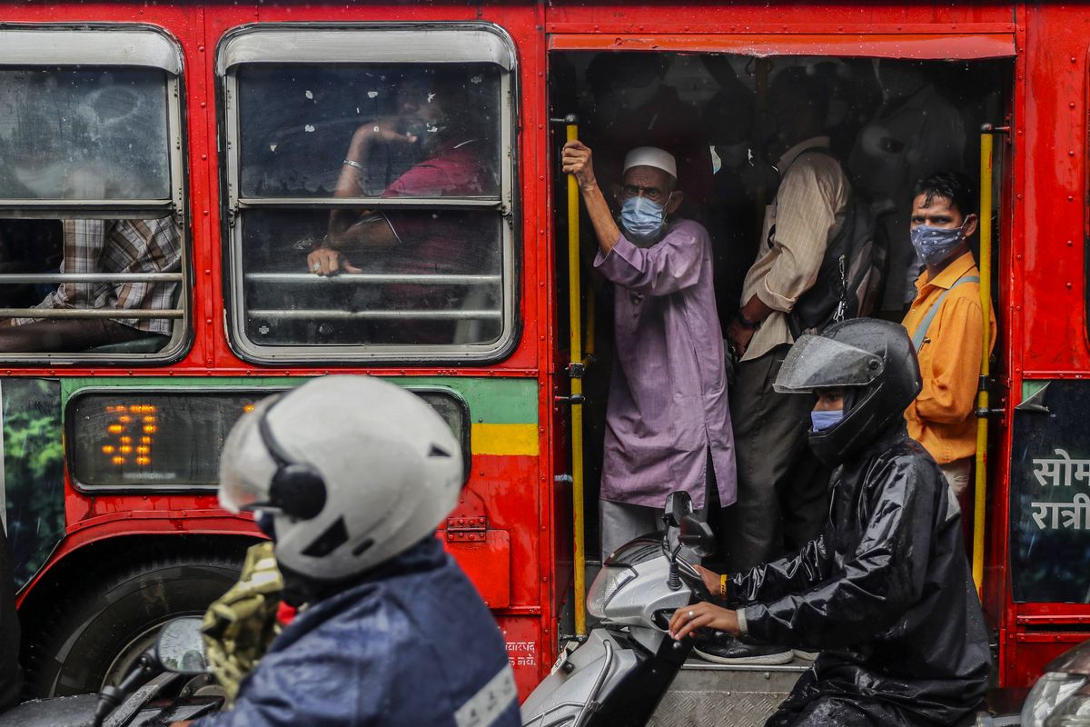 People wearing masks as a precaution against the coronavirus travel in a bus Tuesday in Mumbai, India.  (Rafiq Maqbool)